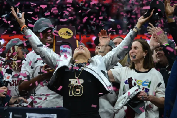 South Carolina Head Coach Dawn Staley celebrating the national championship under confetti with her team. 